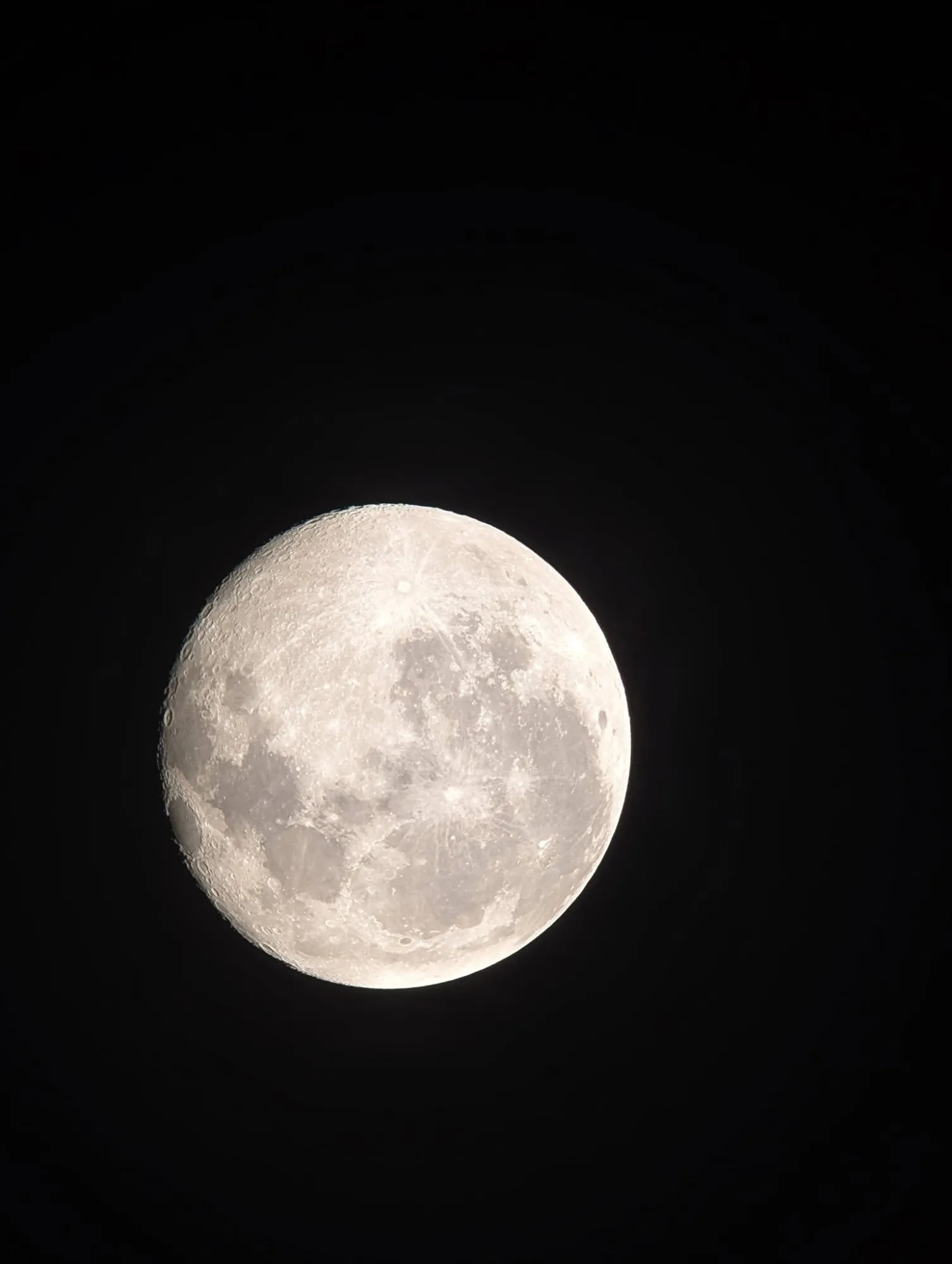 The full Moon, bright and white against a black sky.