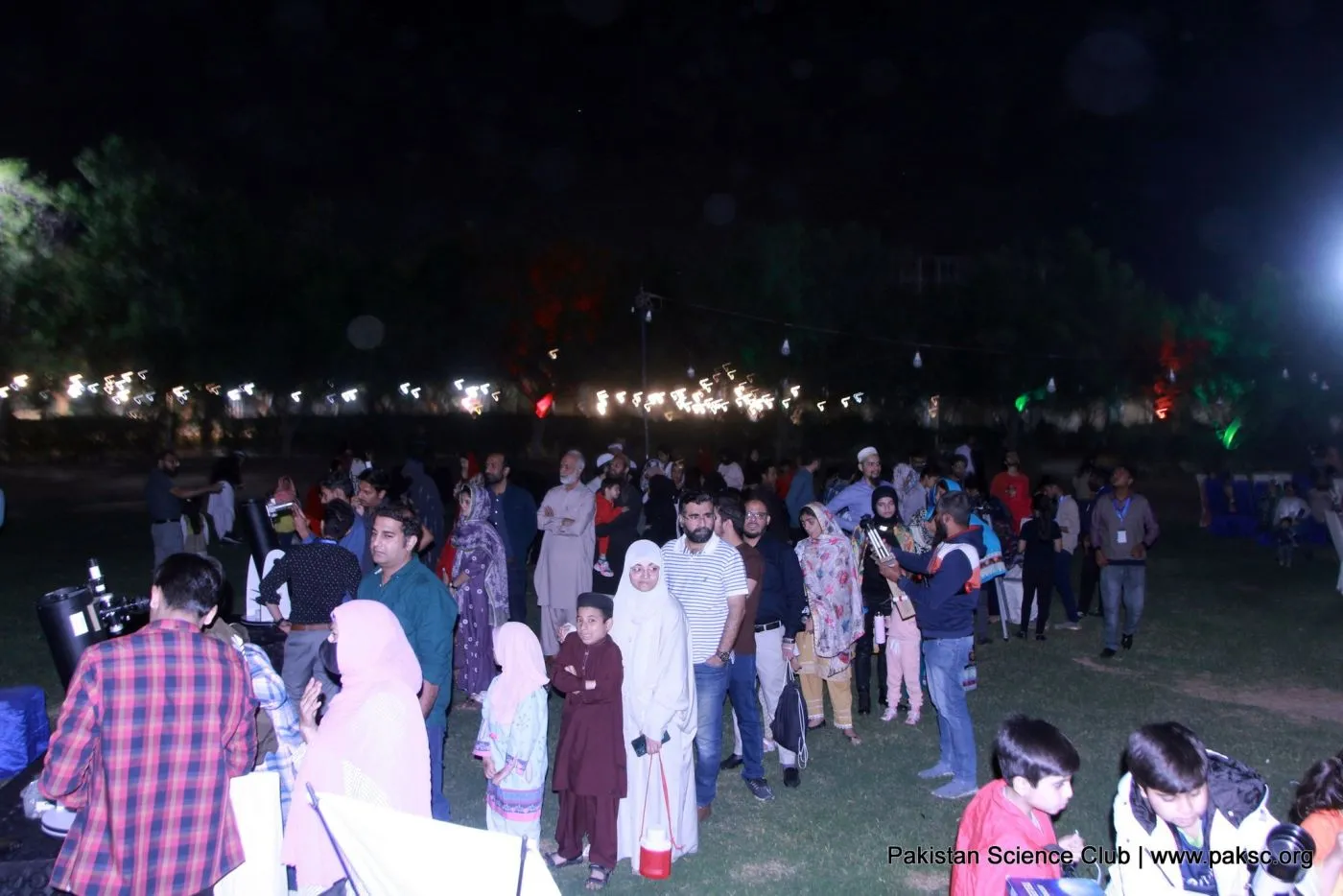 Families gather on the lawn at night for the Pakistan Science Club astronomy night at Dream World Resort, Karachi.